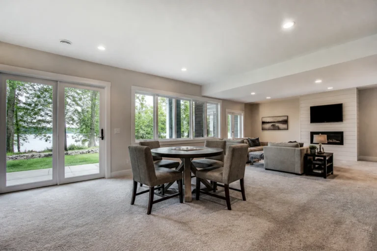 AI-generated walkout basement lounge concept with glass patio doors, a game table and a wooded view